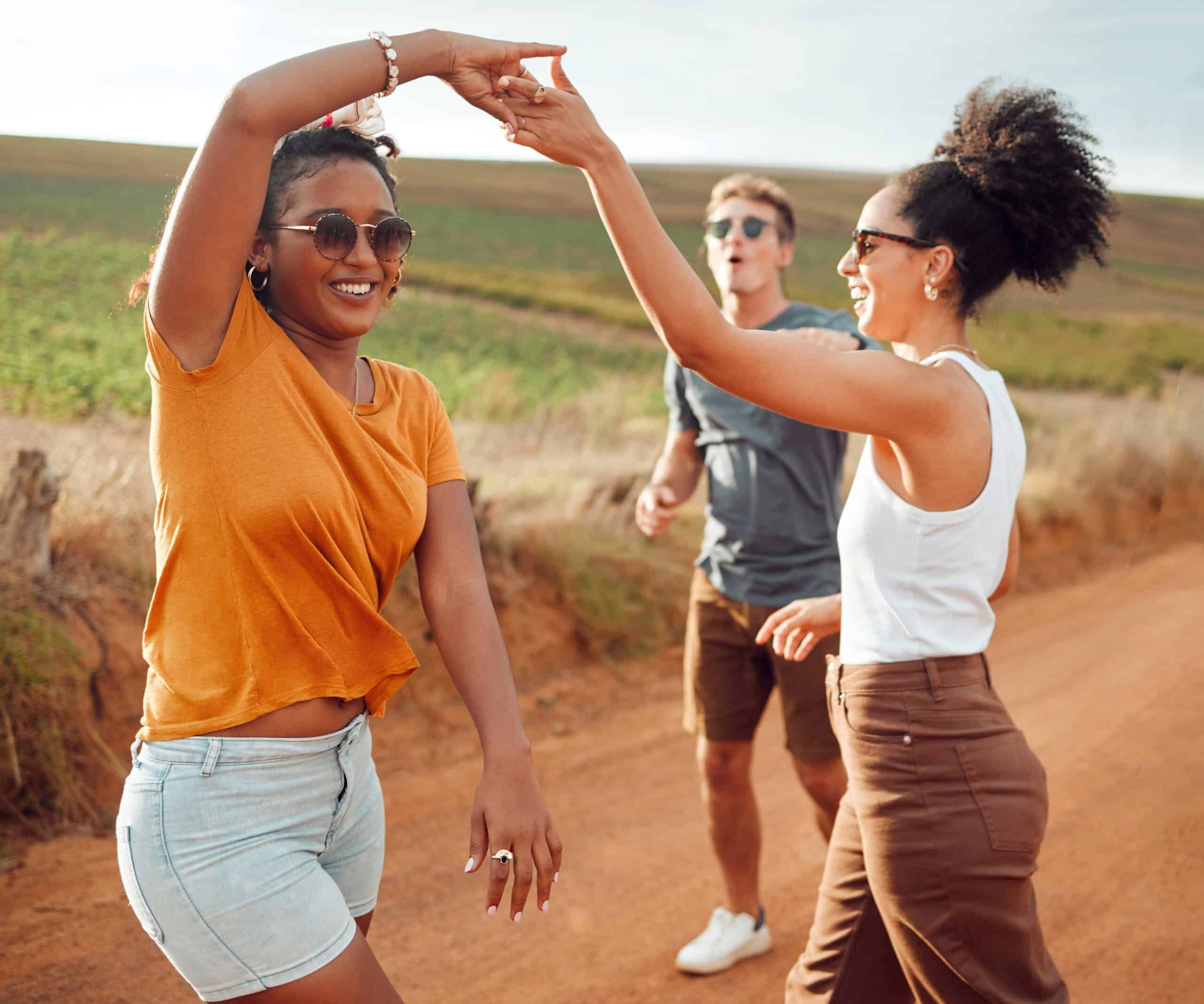 Two women and a man outside all celebrating and goofing around having overcome mental health issues.