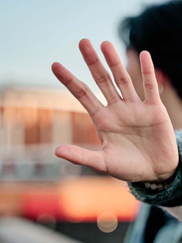 Person holding hand to conceptually show avoidance as a symptom of panic attacks.