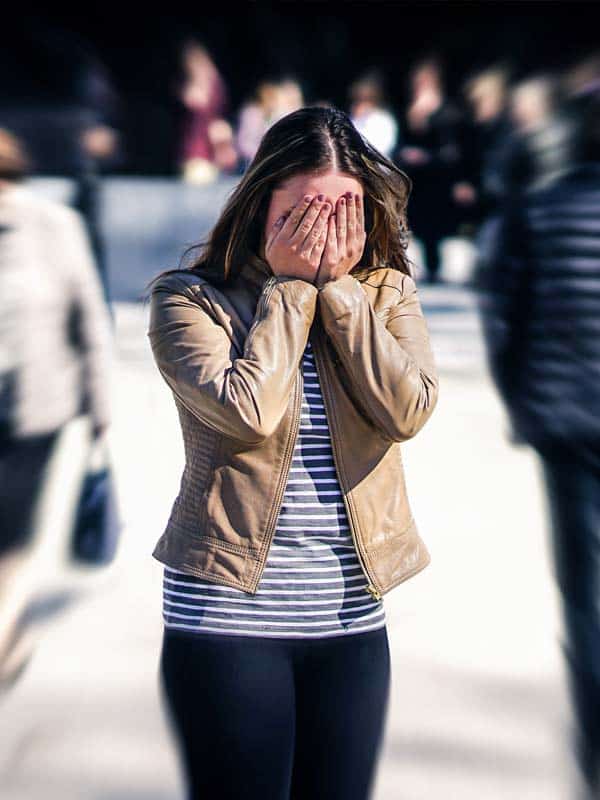 woman shutting down in a crowd due to social anxiety disorder.