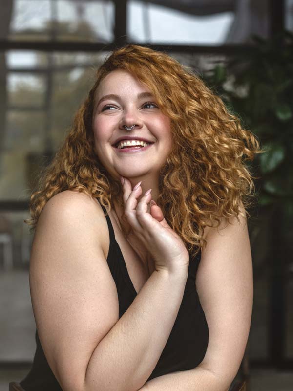 Happy smiling woman with red hair having overcome persistent depression.