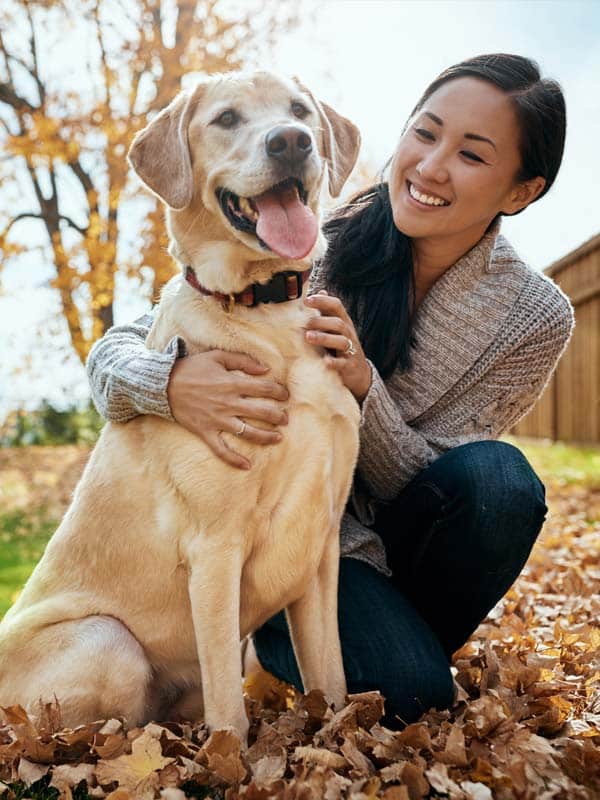 Woman happy playing with dog outside no longer dealing with self harm.