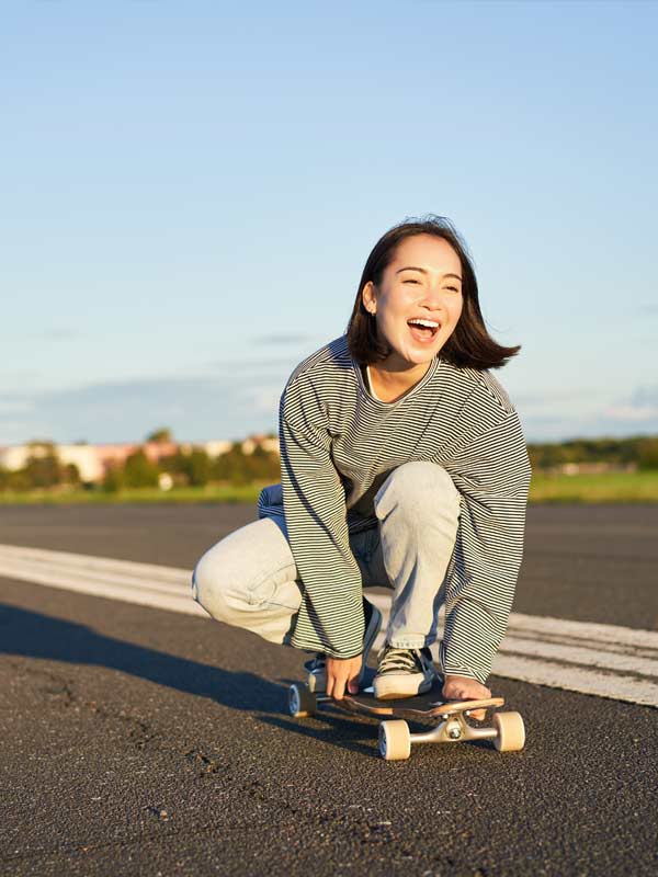 Young woman on a skateboard smiling and feeling stable on her meds.
