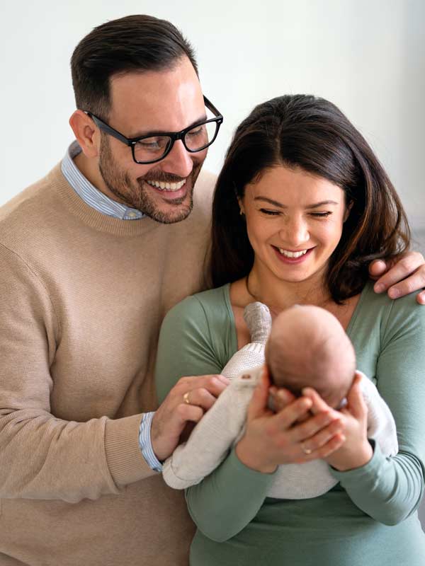 Image of a couple holding their newborn baby.